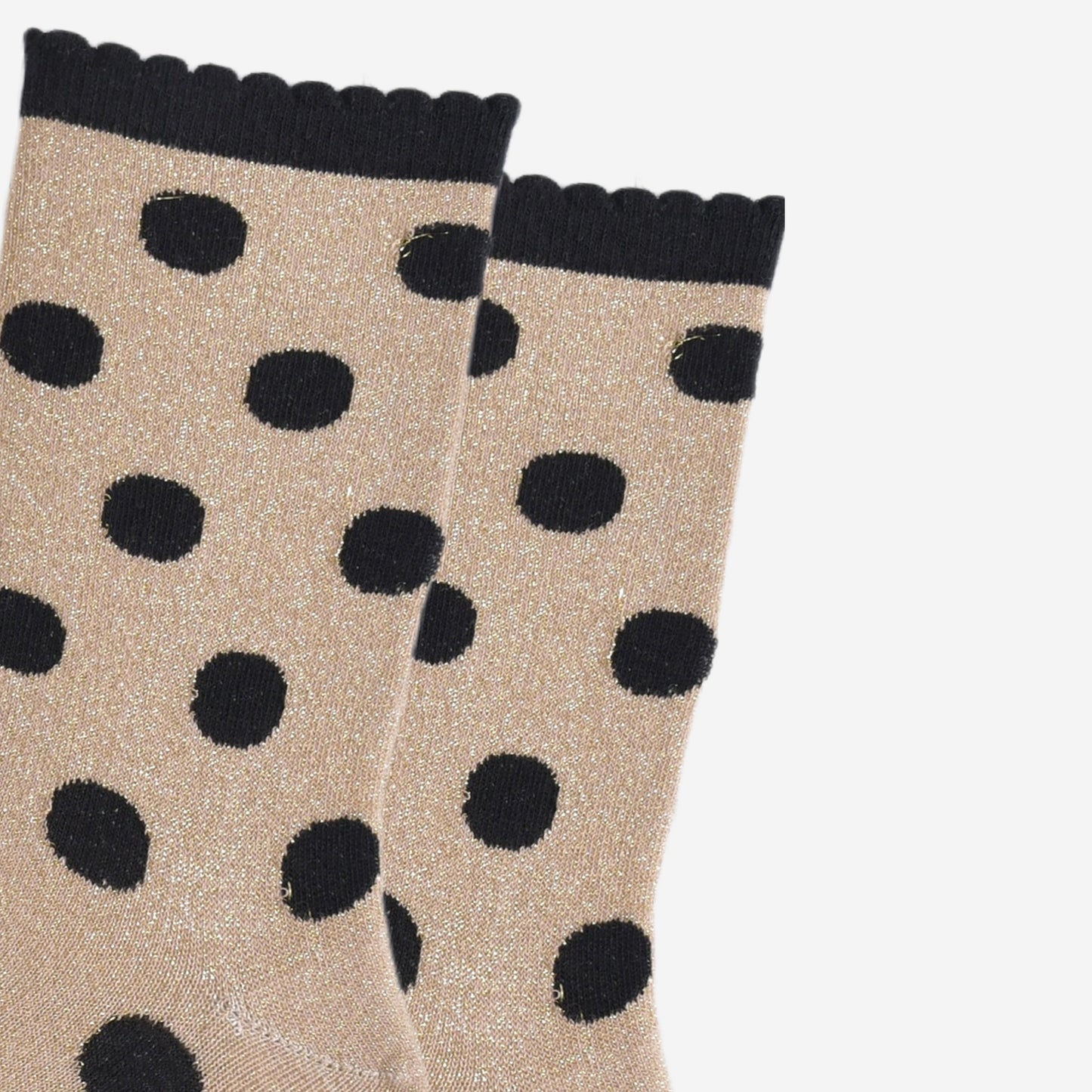 close up of the black polka dot pattern and all over silver glitter on the gold ankle socks