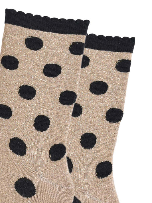close up of the black polka dot pattern and all over silver glitter on the gold ankle socks