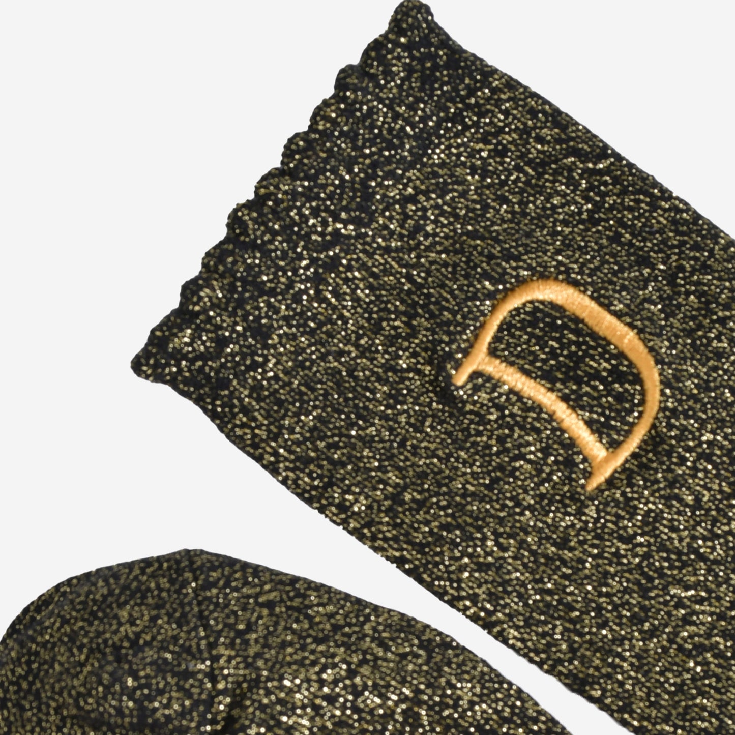 close up of the scalloped cuff on the socks, the toe is the same black and gold as the rest of the socks