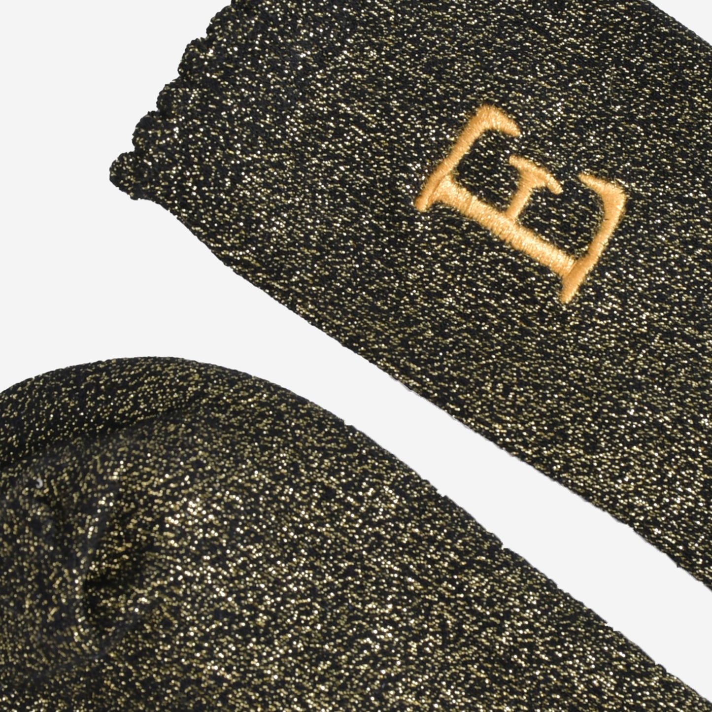 close up of the scalloped cuff on the socks, the toe is the same black and gold as the rest of the socks