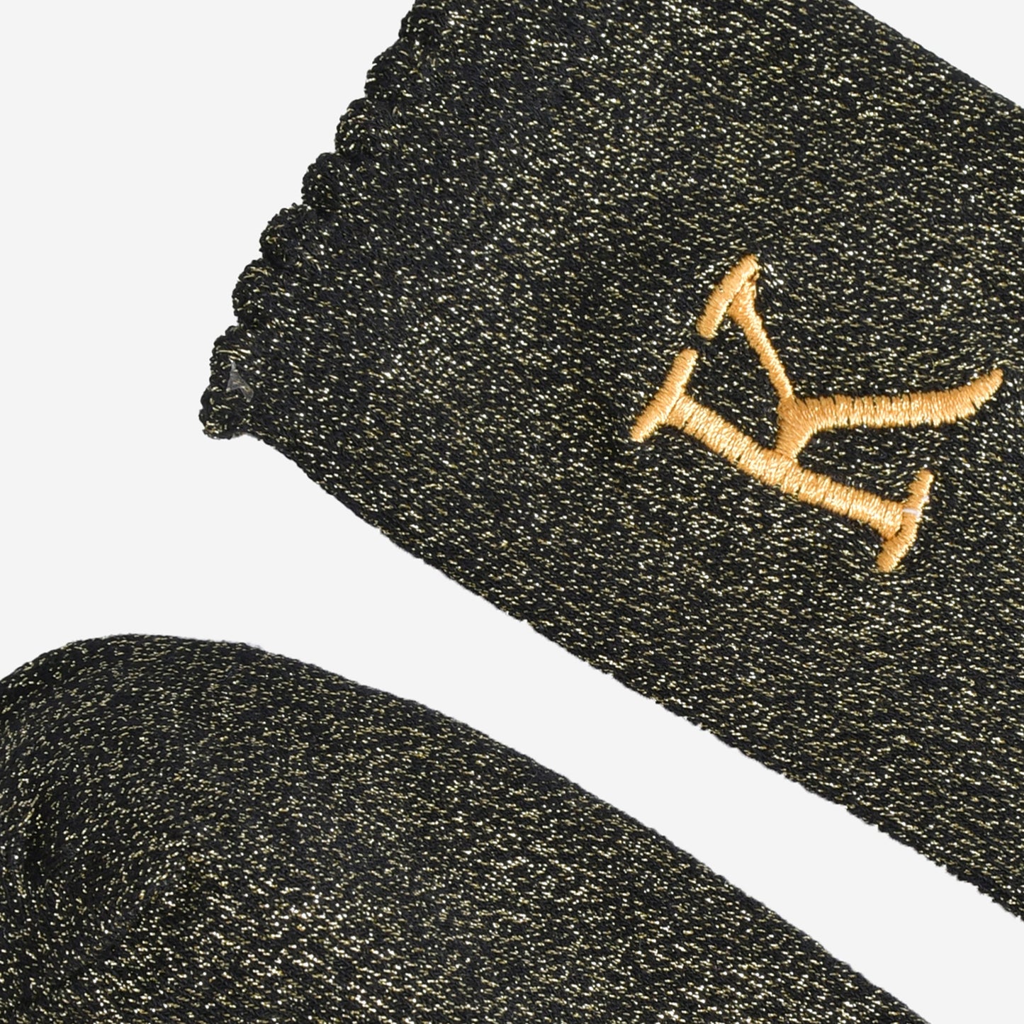 close up of the scalloped cuff on the socks, the toe is the same black and gold as the rest of the socks