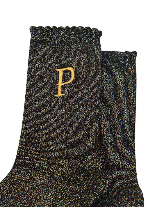 close up of the gold embroidered capital letter p on the ankle of the socks