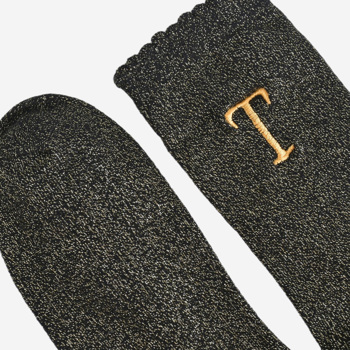 close up of the scalloped cuff on the socks, the toe is the same black and gold as the rest of the socks