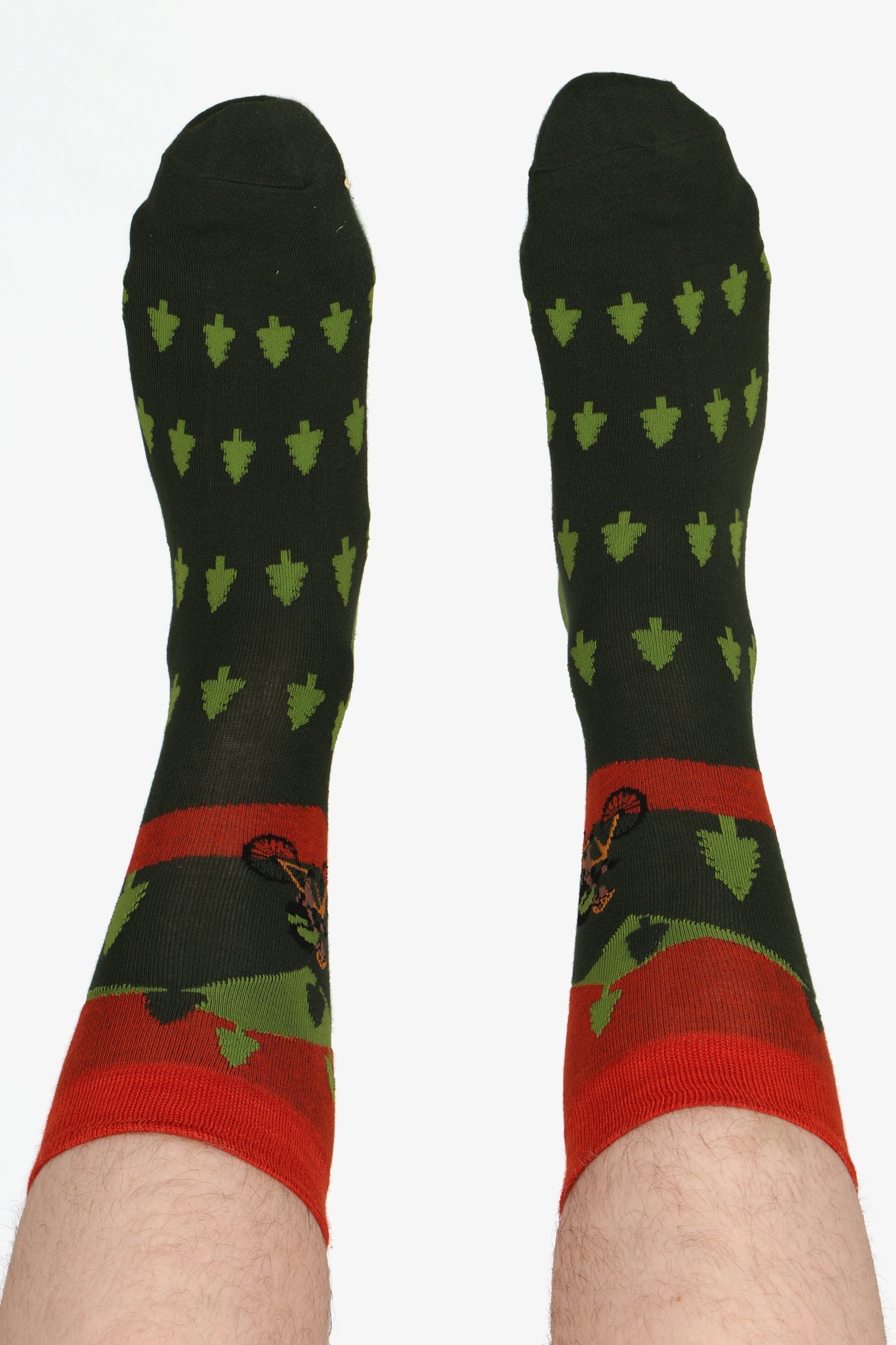 Mne's feet in the air wearing sock talk socks. Showing the tree and bike print of the socks