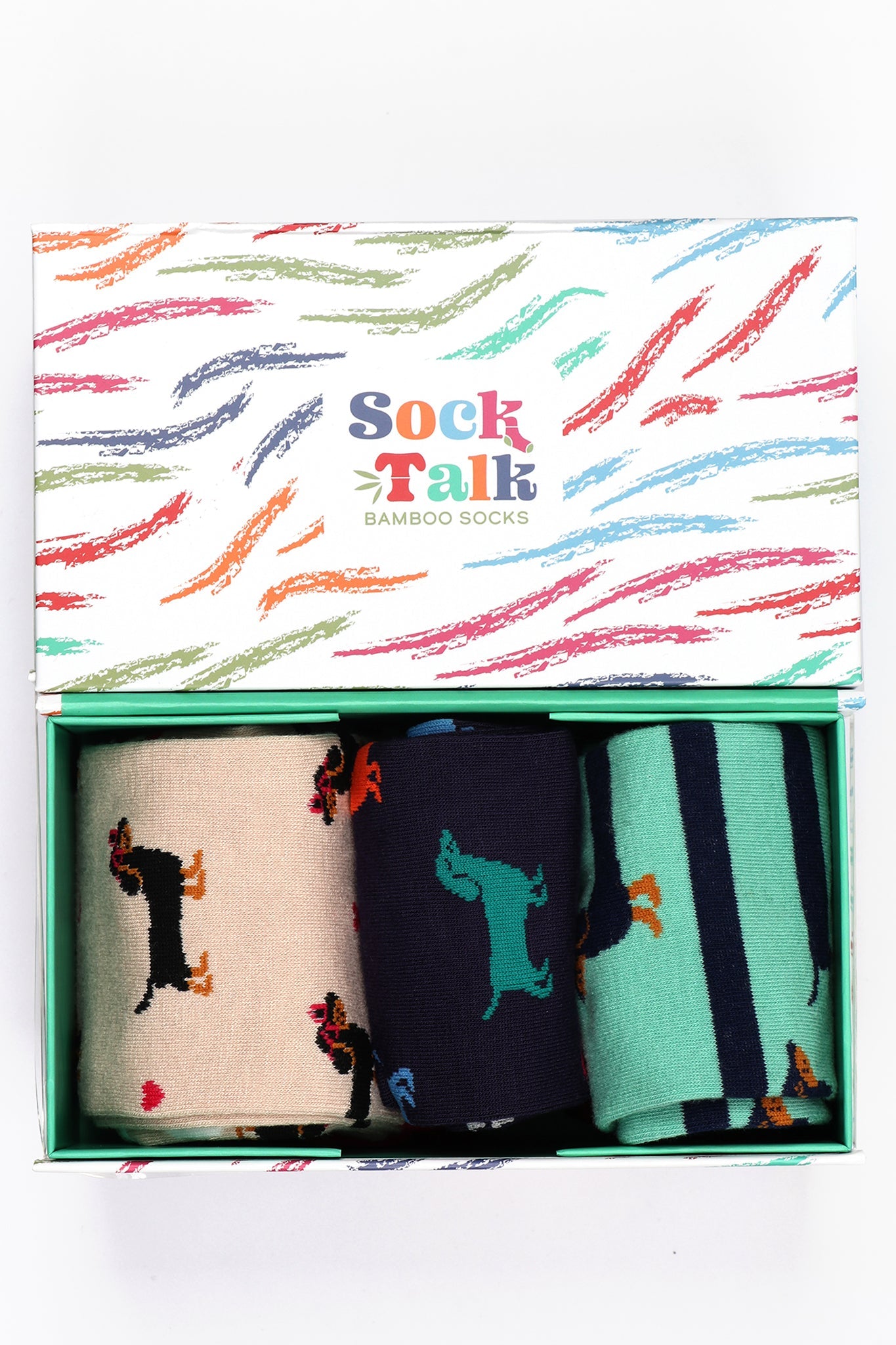 white gift box with a multicoloured brushstroke pattern and three pairs of sausage dog pattern bamboo socks