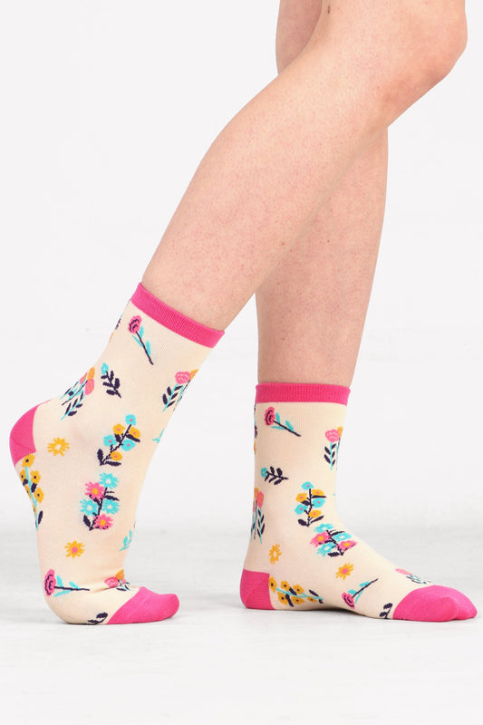 Model wearing wild flower print bamboo socks in cream and pink