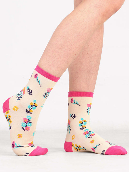 Model wearing wild flower print bamboo socks in cream and pink