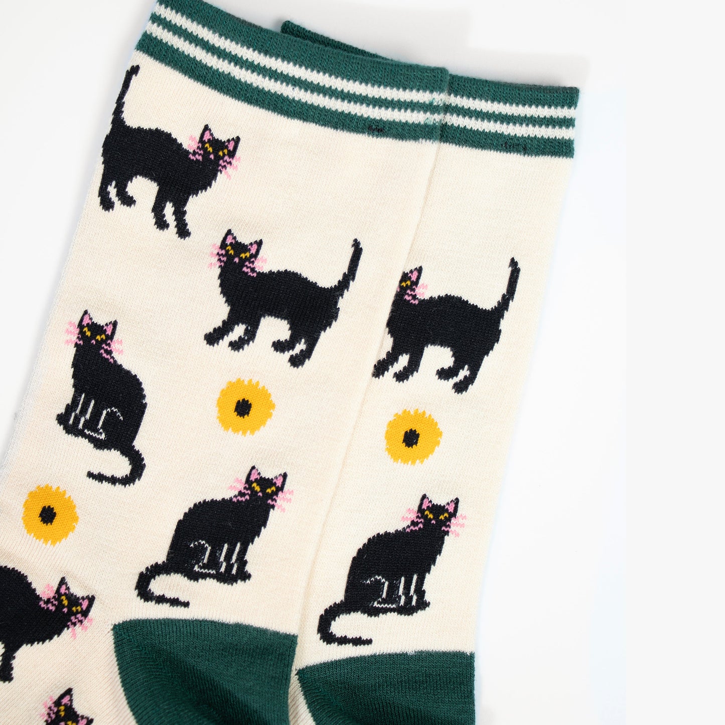 close up of the black cat and yellow sunflower design. the cats are standing and sitting and have pink whiskers, the sunflowers are yellow with a black centre.