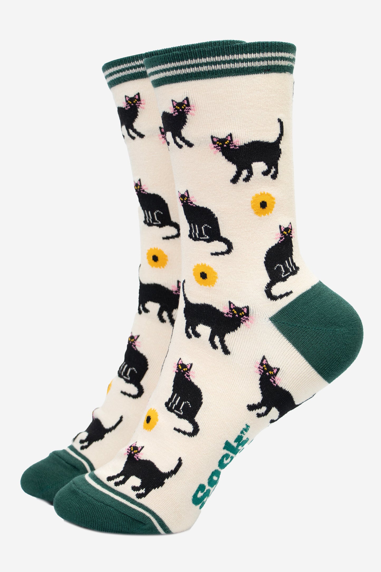 cream socks with green toe, heel and striped cuff. there is a pattern of black cats and yellow sunflowers all over the socks