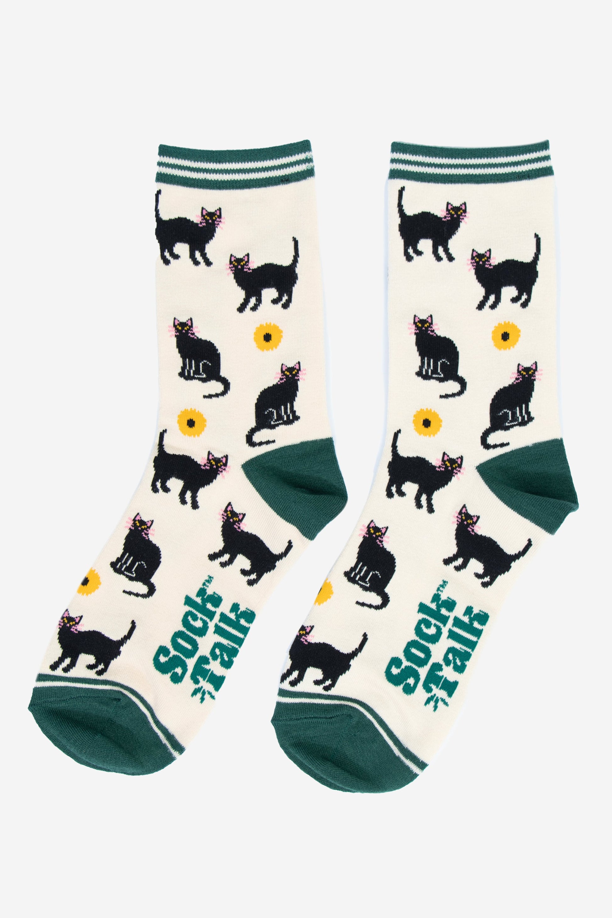 showing the black cat socks laying flat, the pattern of cats and sunflowers is all over the socks, the cream background is contrasted by green heel, toe and stiped cuffs