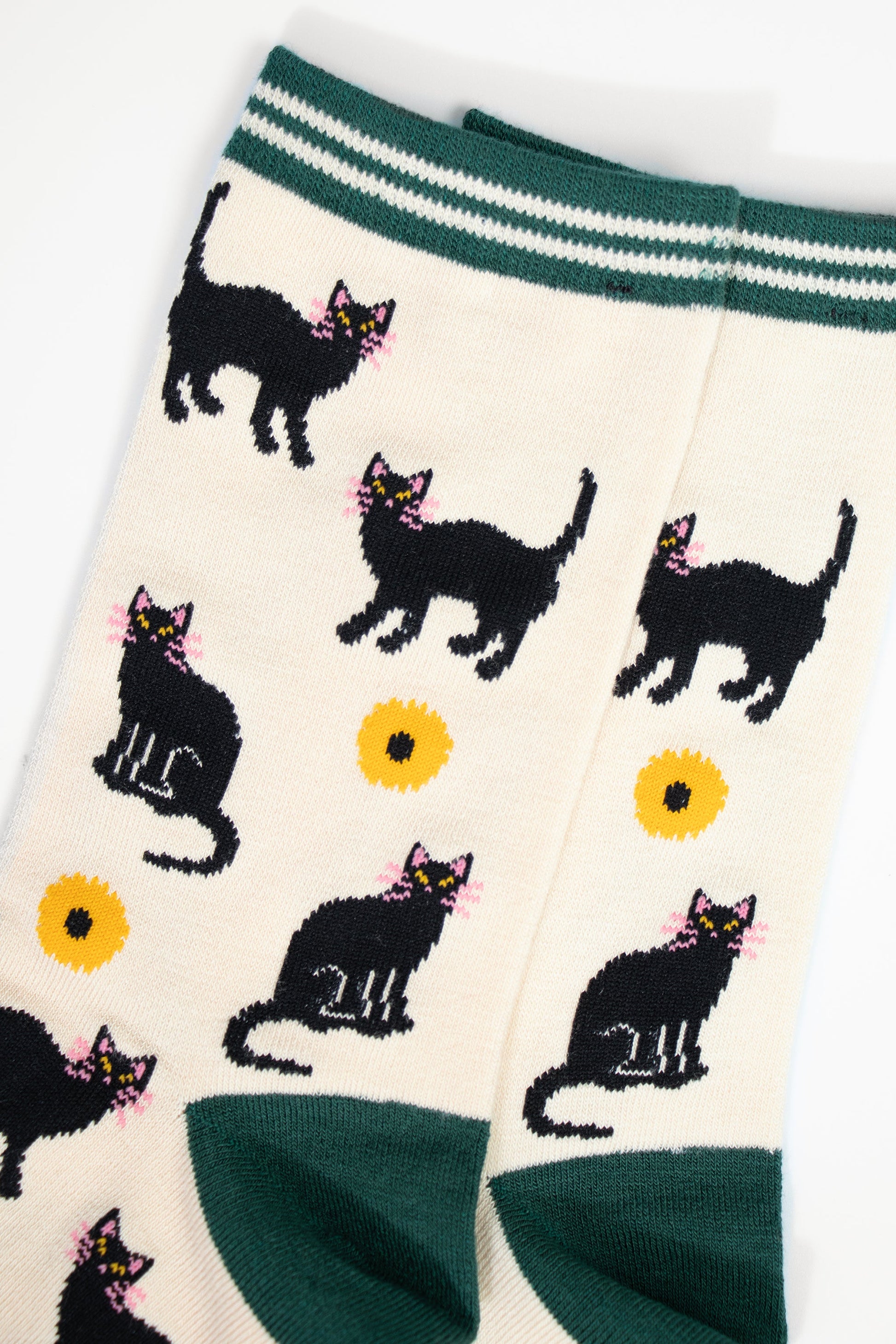 close up of the black cat and yellow sunflower design. the cats are standing and sitting and have pink whiskers, the sunflowers are yellow with a black centre.