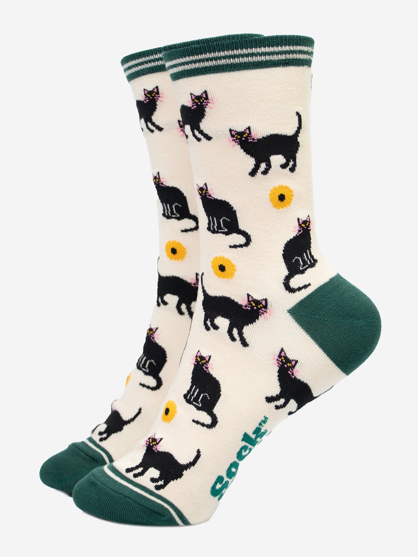 cream socks with green toe, heel and striped cuff. there is a pattern of black cats and yellow sunflowers all over the socks