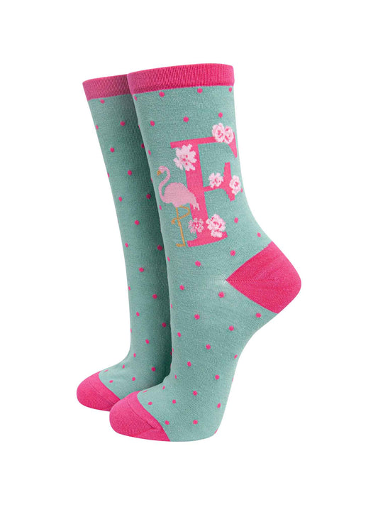 green, pink bamboo socks with the letter F and a flamingo