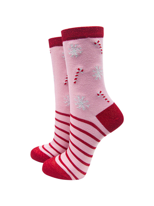 pink bamboo socks with a pattern of red candy canes, red striped and white snowflakes