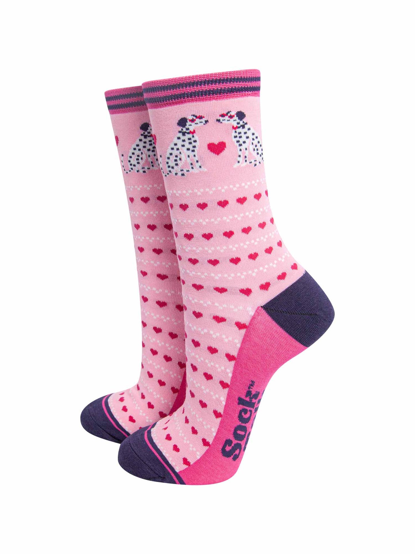 light pink bamboo socks with a pattern of pink love hearts and two dalmatians. the sole is fuchsia pink, the heel and toe are navy blue. the cuff of the socks is straight cut and has a navy blue and fuchsia pink stripe.