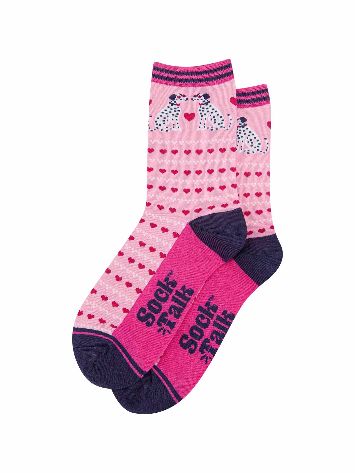 the pair of pink dalmatian dog socks laying flat, one overlapping the other. showing clearly the light pink background of the socks which is contrasted by the repeating rows of fuchsia pink love hearts. the dalmatians feature on the ankle of the socks. the sock talk logo is visible on the base of the sole. 
