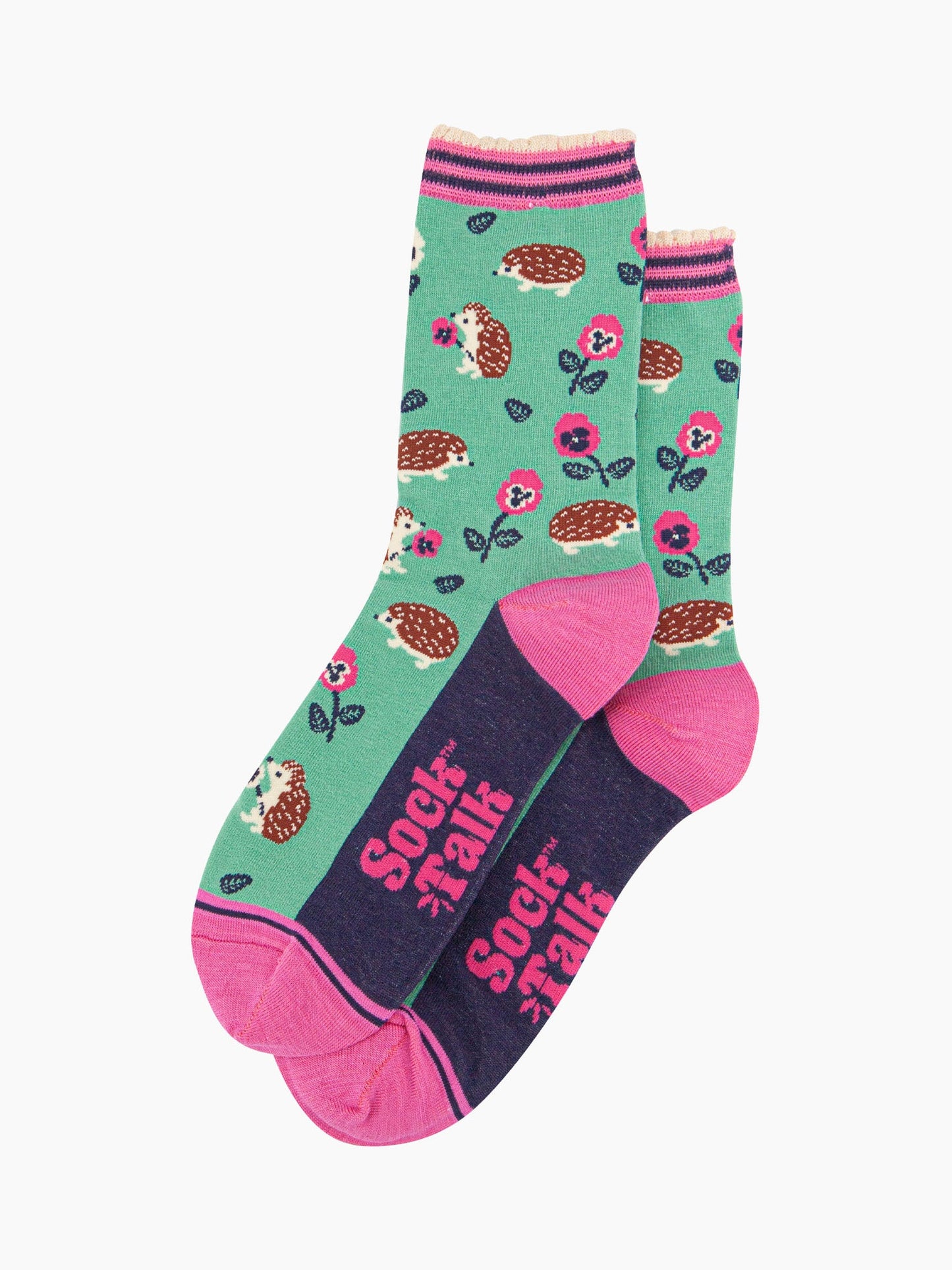 the pair of mint green hedgehog socks laying flat one overlapping the other. showing clearly the green background of the socks which is contrasted by the all over pattern of hedgehogs, flowers and leaves.  the sock talk logo is pink and visible on the base of the sole. 