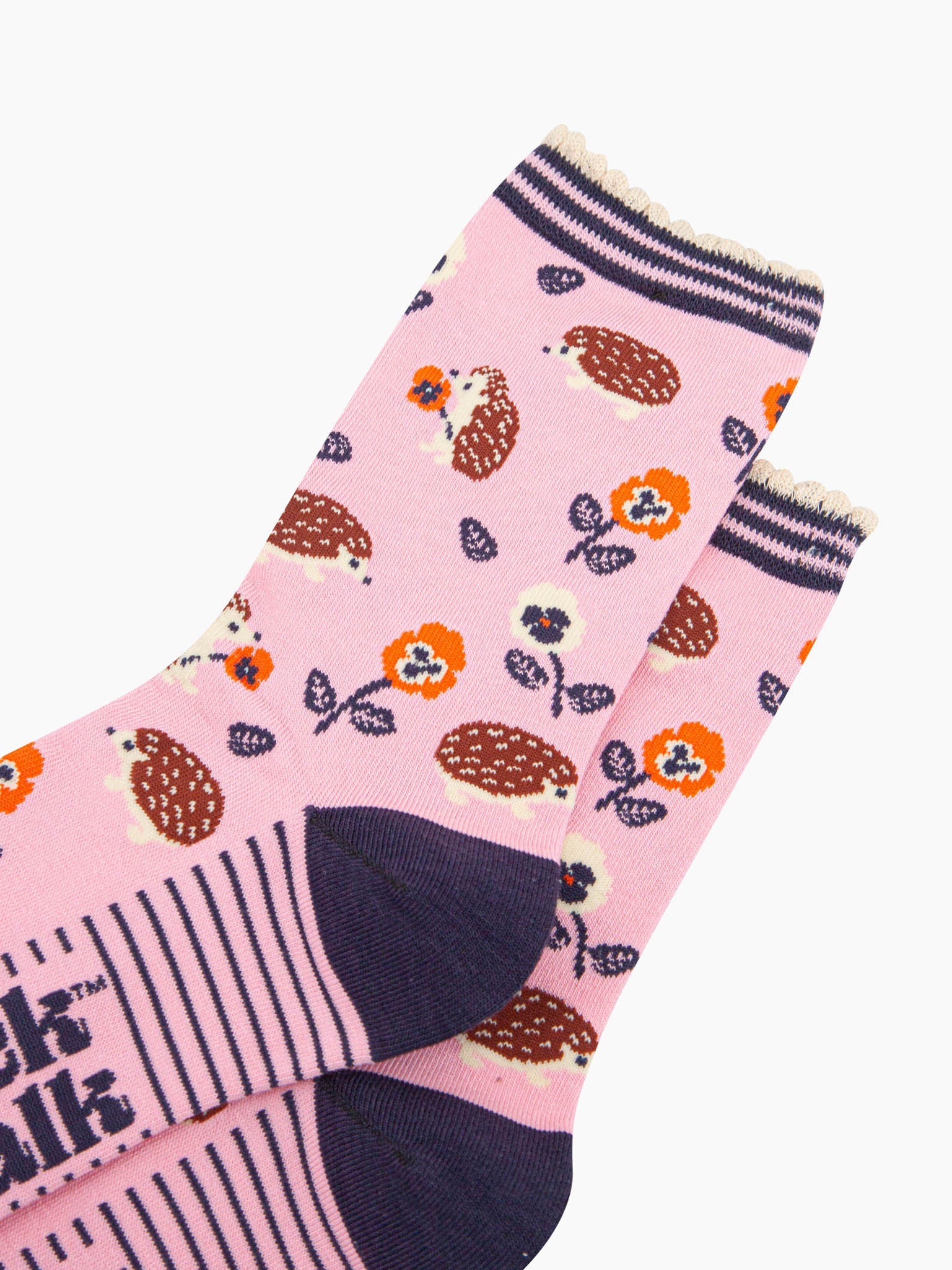 close up of the pattern. the hedgehogs are brown and beige, some are sitting holding orange pansy flowers, others are walking among the flowers. 