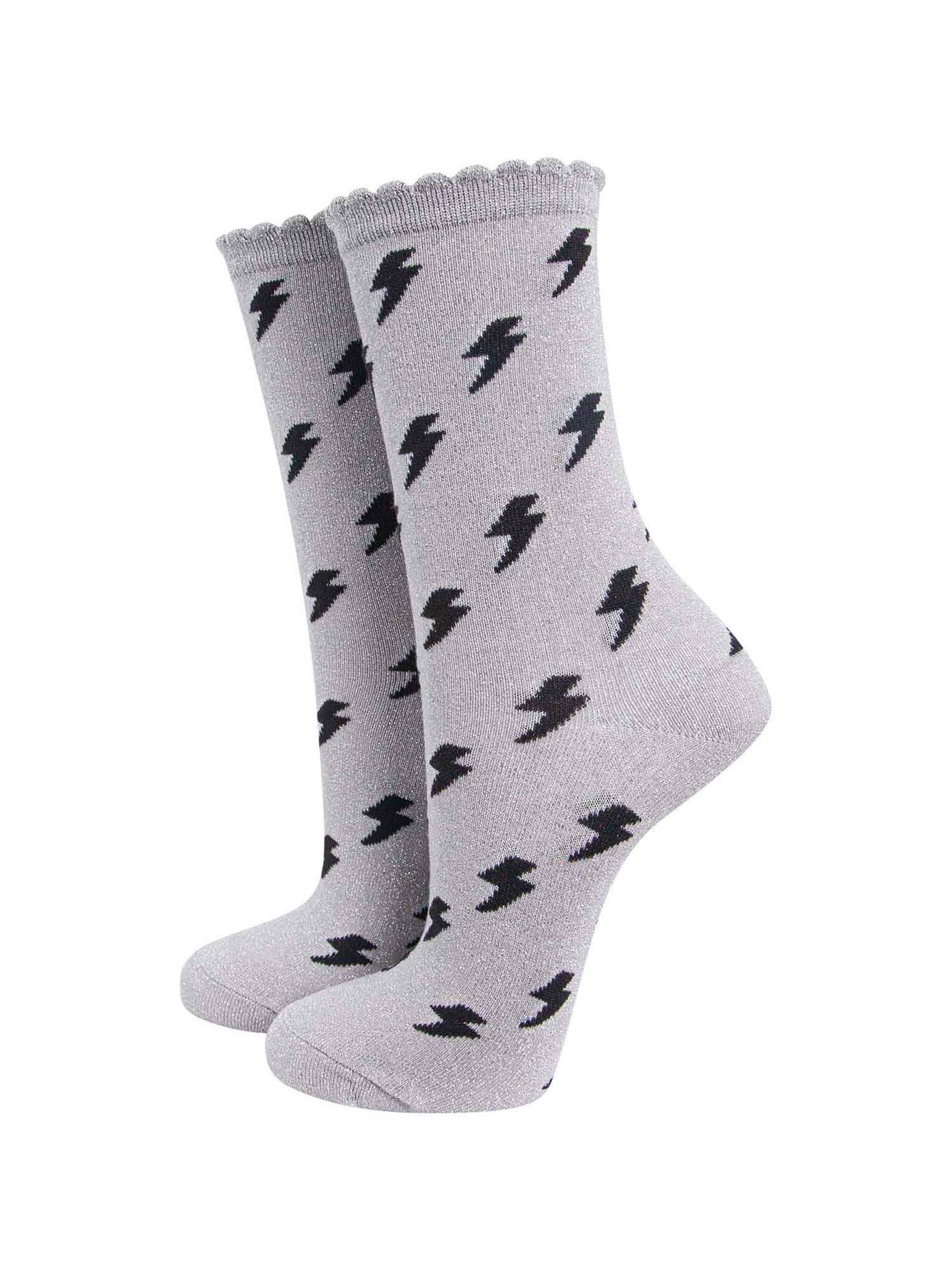 light grey cotton ankle socks with an all over black lightning bolt print pattern and silver glitter shimmer, the socks have scalloped cuffs
