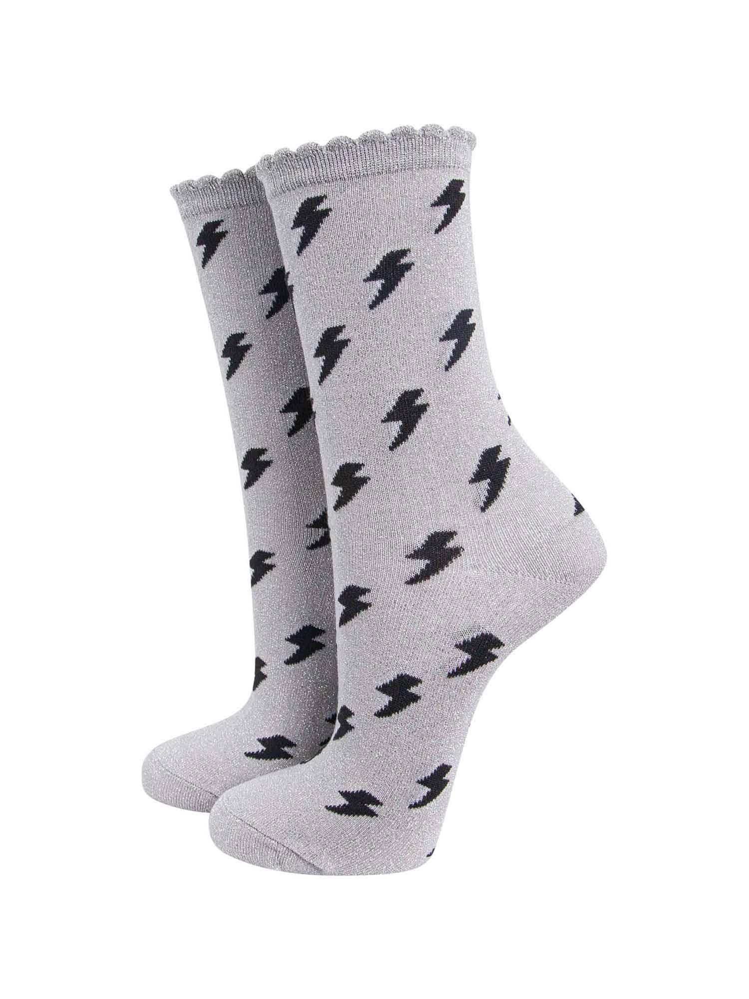 light grey cotton ankle socks with an all over black lightning bolt print pattern and silver glitter shimmer, the socks have scalloped cuffs
