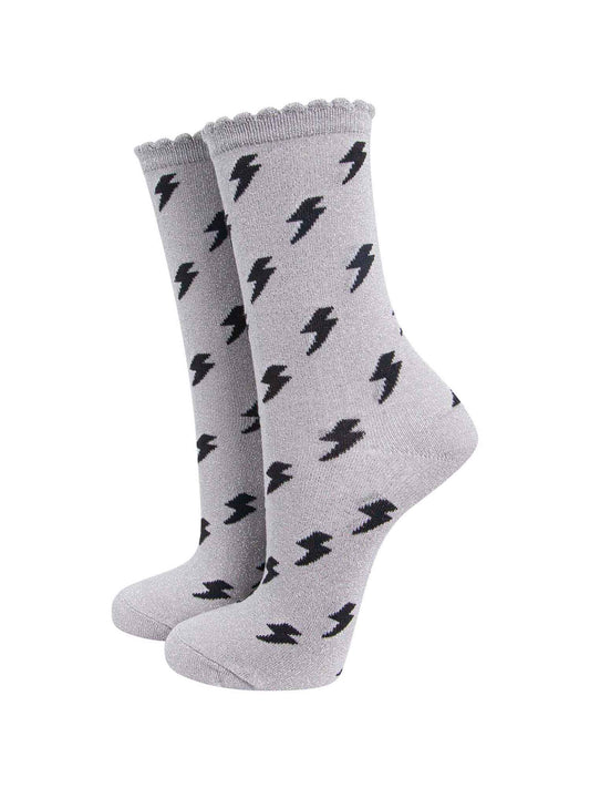 light grey cotton ankle socks with an all over black lightning bolt print pattern and silver glitter shimmer, the socks have scalloped cuffs
