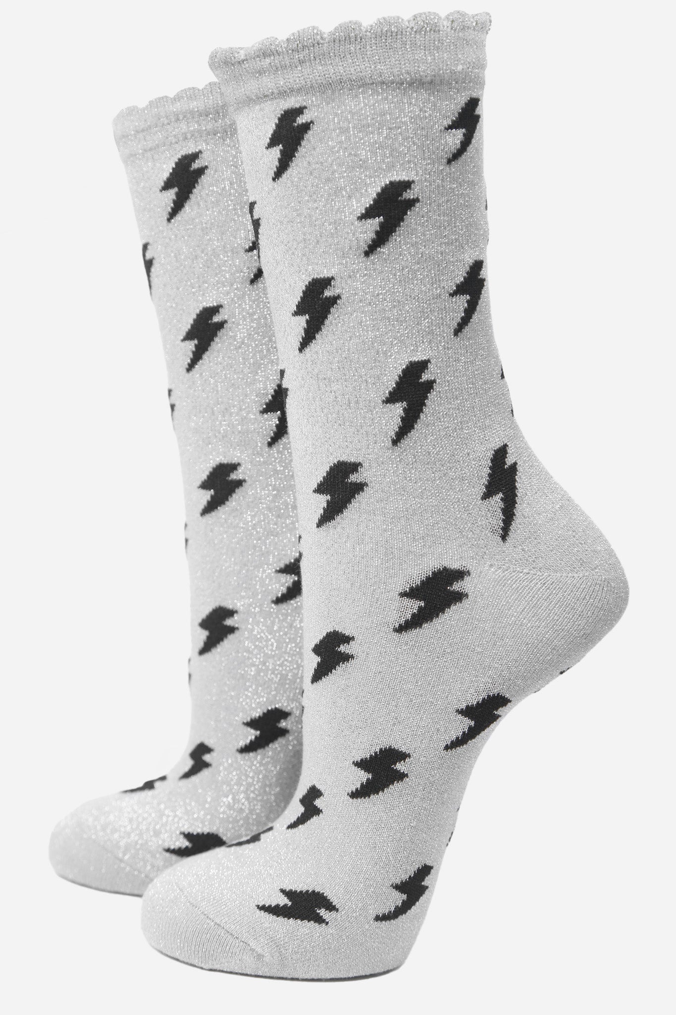 light grey cotton ankle socks with an all over black lightning bolt print pattern and silver glitter shimmer, the socks have scalloped cuffs