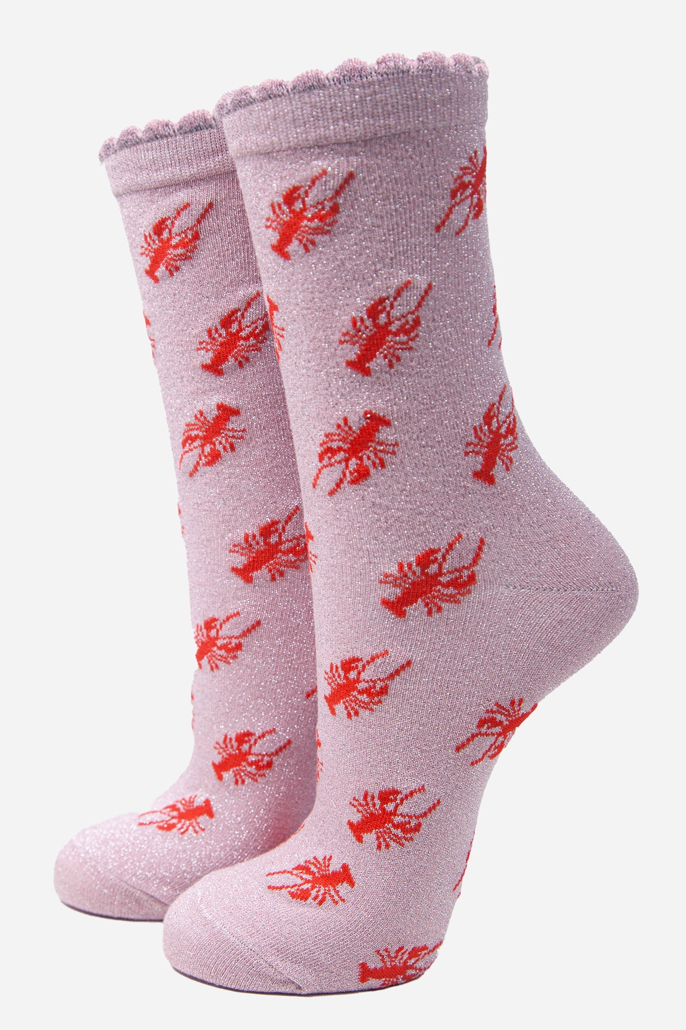 pink cotton socks with an all over red lobster print pattern and silver glitter shimmer, the socks have a scalloped cuff edge