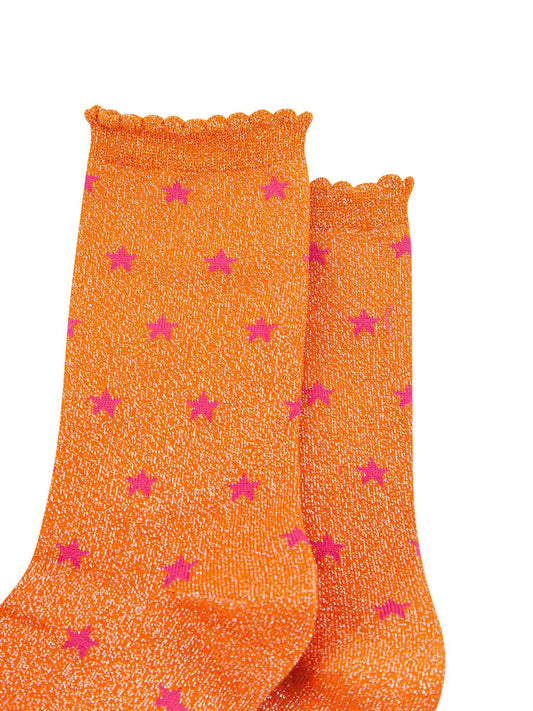 close up of the pink star pattern on the orange glitter socks