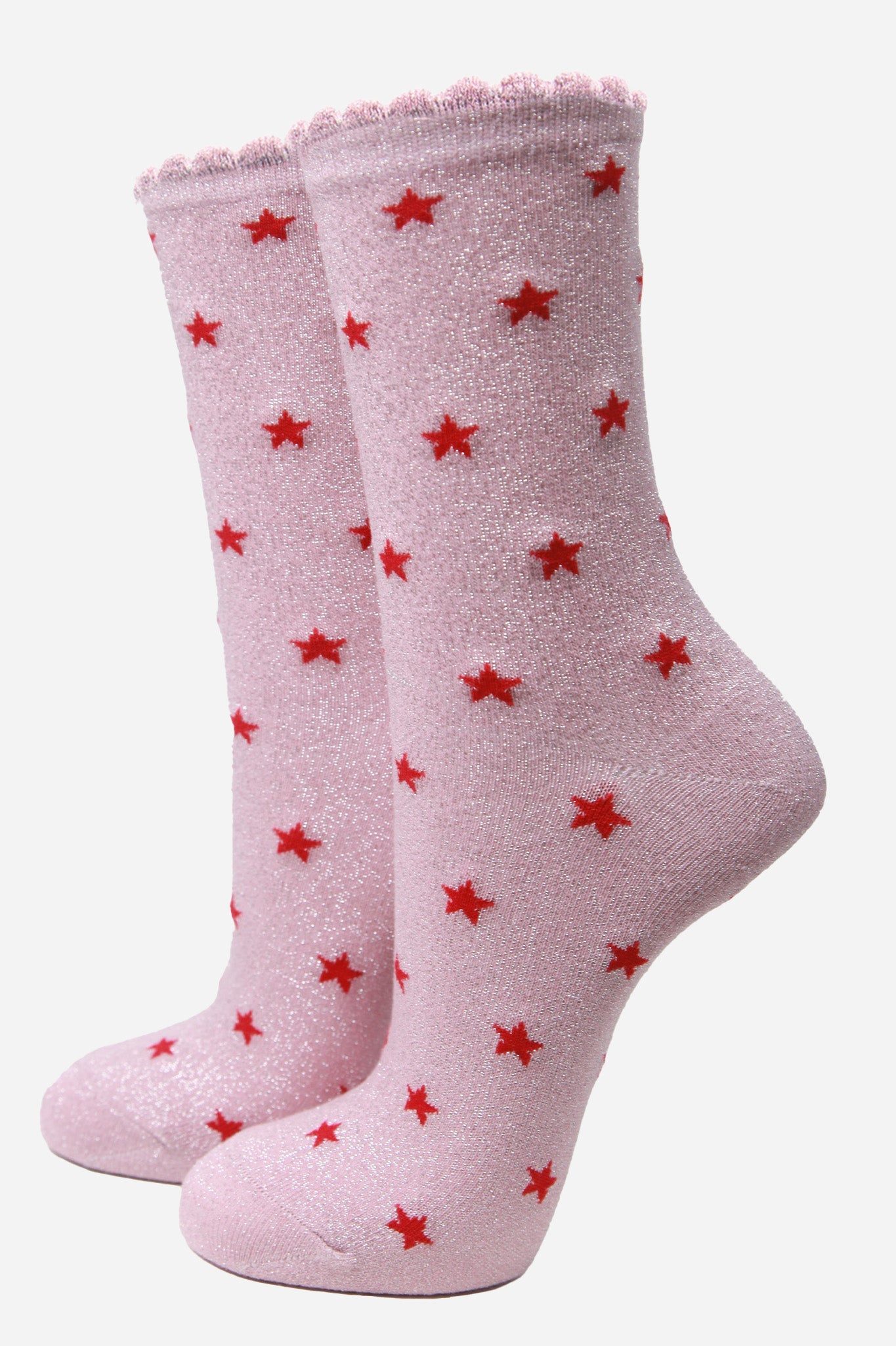 pink cotton ankle socks with an all over red star print pattern and silver glitter shimmer, the socks have scalloped cuffs