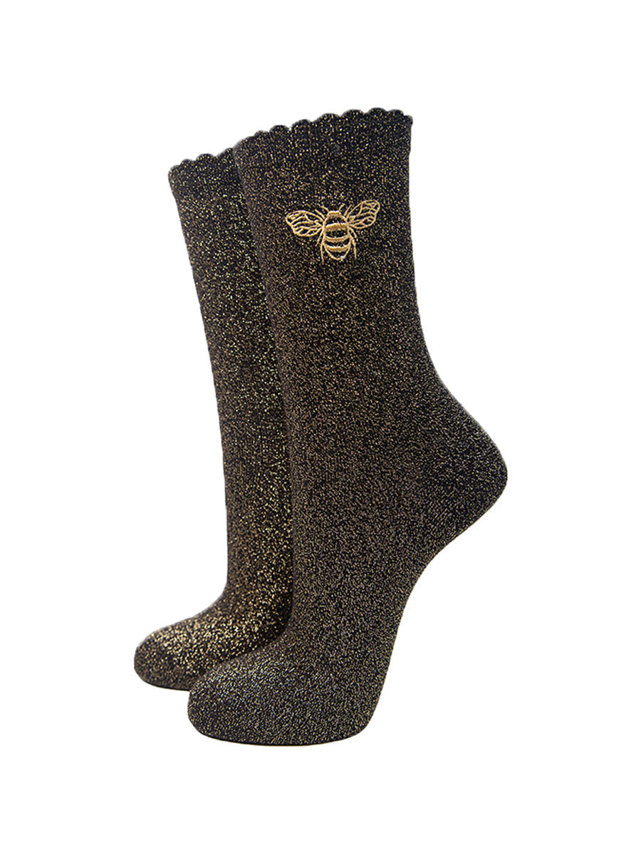 black glitter socks with an all over gold sparkle and a gold embroidered bee on the ankle, the socks have scalloped cuffs