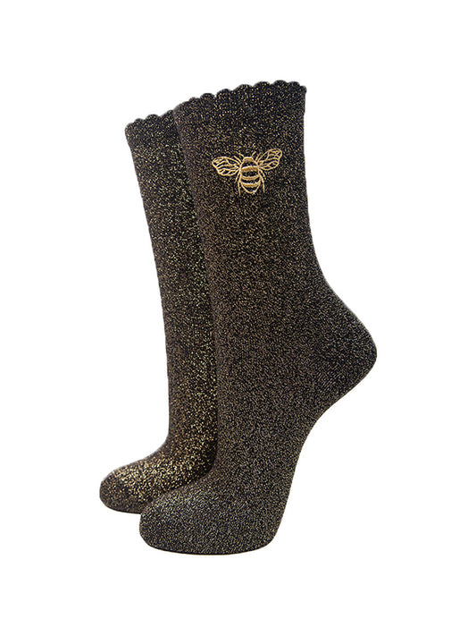 black glitter socks with an all over gold sparkle and a gold embroidered bee on the ankle, the socks have scalloped cuffs