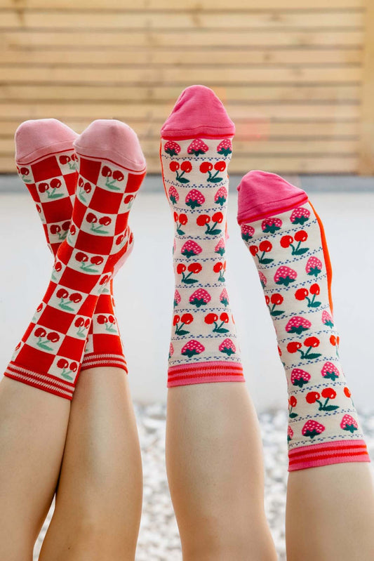 womens-bamboo-socks-cream-red-cherry-squares-and-womens-bamboo-socks-cream-strawberry-cherry-fair-isle-two-woemn-posed-feet-to-sky