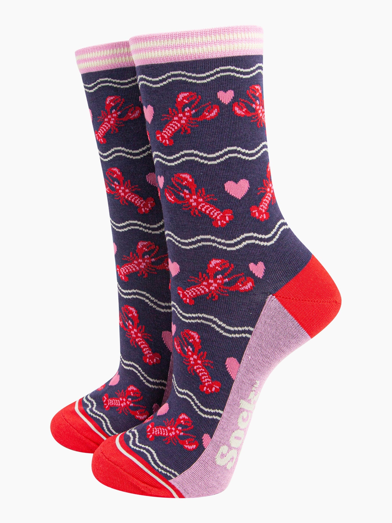 navy blue socks with a pattern of red lobsters and pink love hearts. the socks have a pink and white striped cuff and contrasting red heel and toe