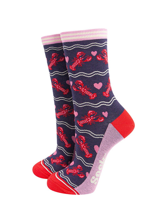 navy blue socks with a pattern of red lobsters and pink love hearts. the socks have a pink and white striped cuff and contrasting red heel and toe
