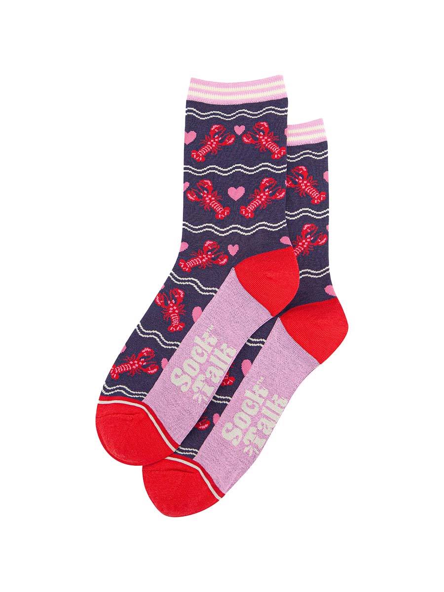 the pair of lobster and love heart socks laying flat, one on top of the other. showing clearly the all over pattern of red lobsters, white wavy lines and pink love hearts. 