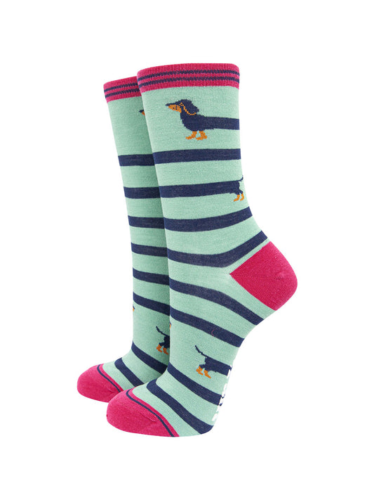 mint green ankle socks with pink heel, toe and cuff with a navy blue sausage dog winding itself around the sock giving the socks a striped appearance