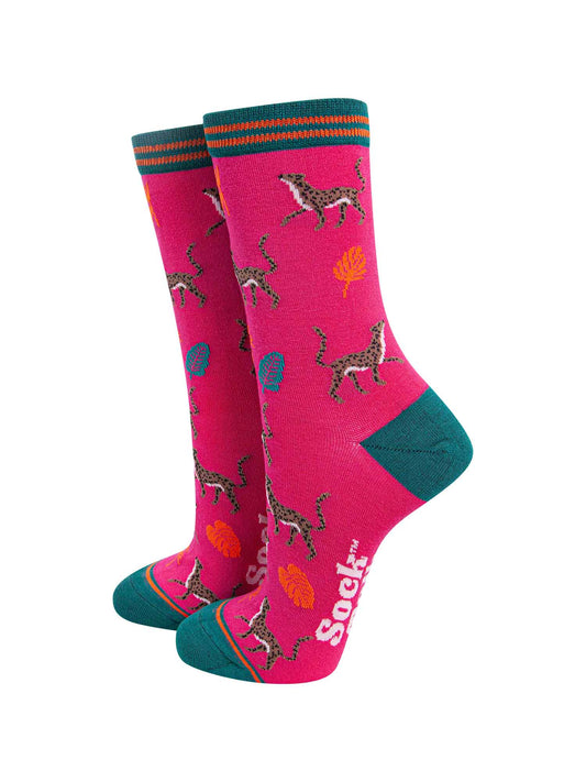 fuchsia pink bamboo socks with a green heel, toe and cuff featuring an pattern of cheetah cats and colourful jungle leaves
