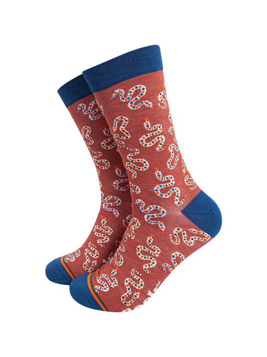 burnt orange bamboo socks with an all over pattern of winding rattle snakes and navy blue heel, toe and cuff