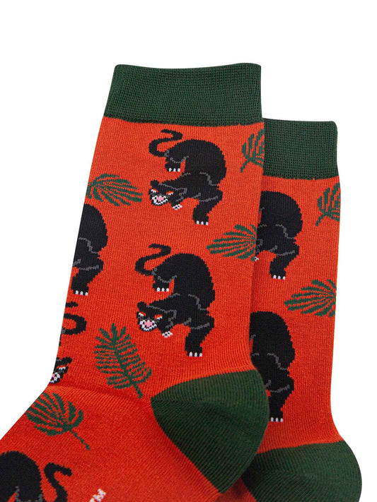 close up of the black panther and leaf print on the orange bamboo socks