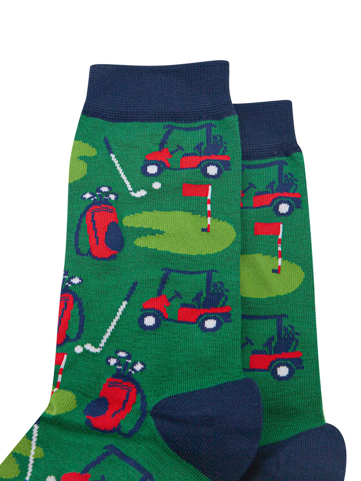 close up of the golf green scene, showing the putting green, golf bag, golf care and golf clubs