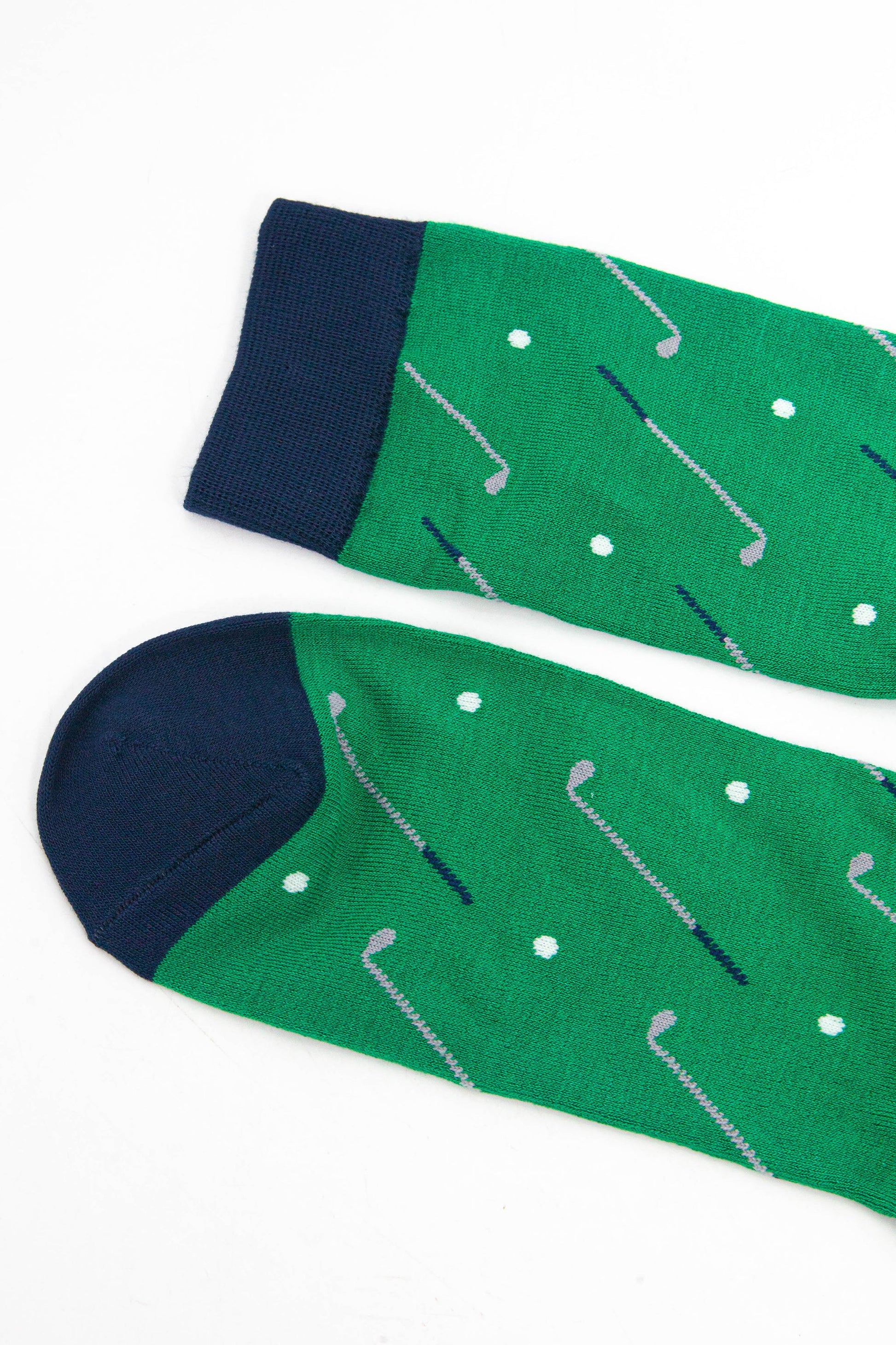 close up of the toe and cuff of the golf socks, both are navy blue in contrast to the green of the socks