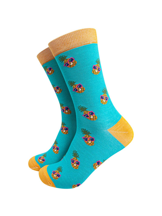turquoise and yellow bamboo socks with an all over pineapple print, the pineapples are wearing pink sunglasses