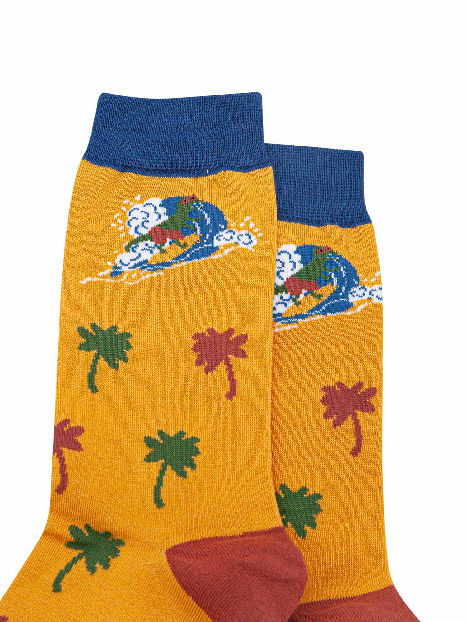 close up of the surfing dinosaur and palm tree design on the yellow and navy blue bamboo socks