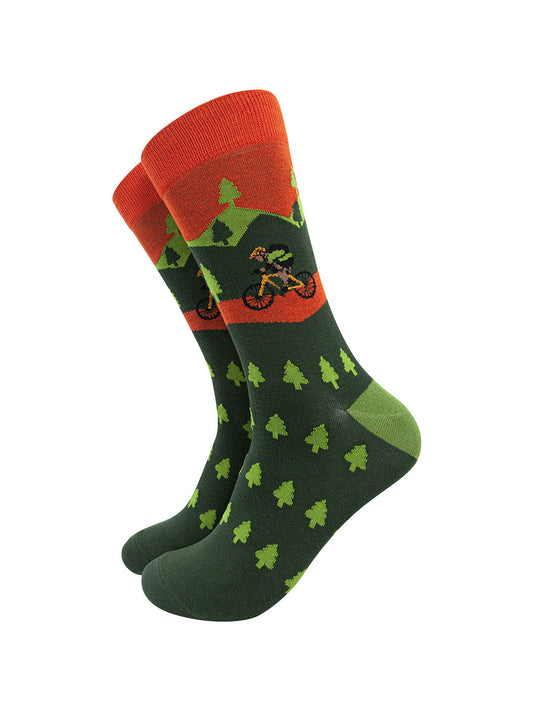 green and orange bamboo socks featuring a forest of trees and a person on a mountain bike