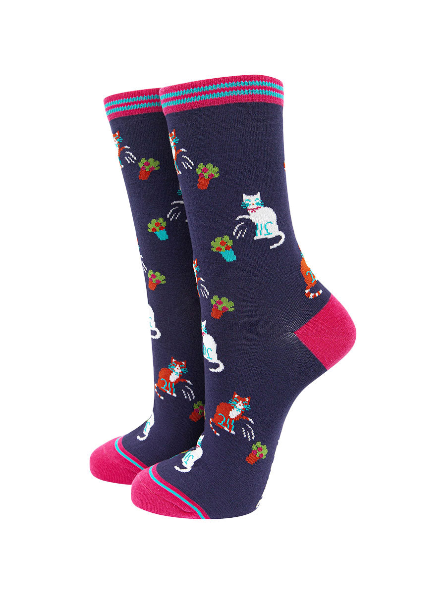 navy blue and pink bamboo socks featuring a funny print with cats knocking over plant pots