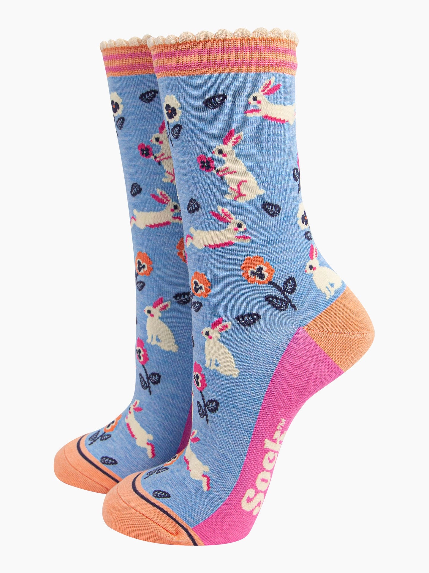 light blue bamboo socks with a pattern of white rabbits and orange and pink flowers. the socks have an orange and pink striped cuff.