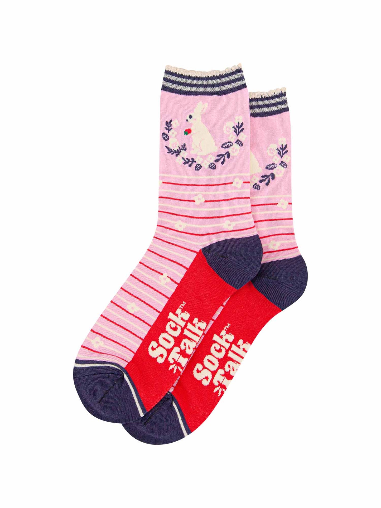 pair of pink rabbit and wreath bamboo socks laying flat, one overlapping the other. showing clearly the pastel pink background of the socks which is contrasted by red and white horizontal pinstripes and white flowers. on the ankle of there is a white rabbit sitting, holding a strawberry in its front paws. the sole of the socks is red, the sock talk logo is shown in cream.