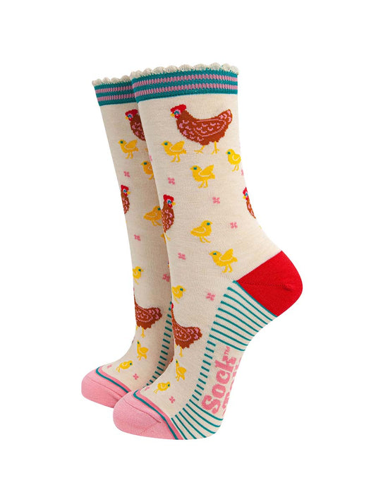 women's bamboo socks cream hen and chicks. cream bamboo socks with a pattern of brown mother hens with yellow baby chicks. the heel is red, the toe is light pink and the cuff is blue and pink striped.
