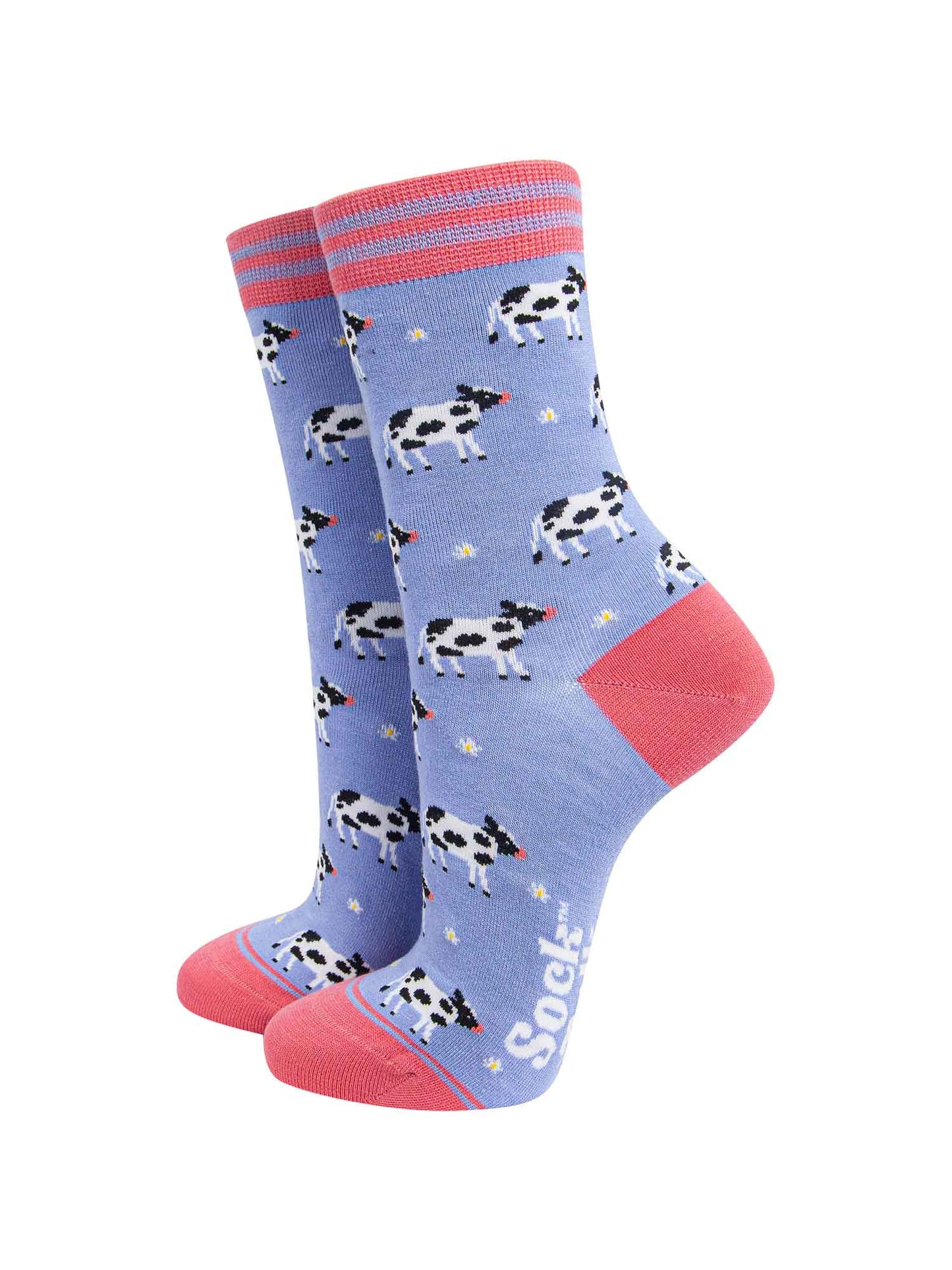 lilac and pink bamboo socks with an all over pattern of black and white cows and daisy flowers