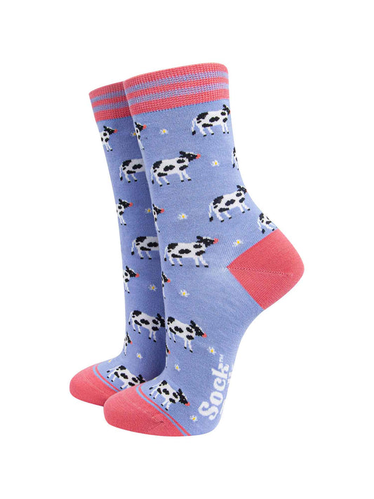lilac and pink bamboo socks with an all over pattern of black and white cows and daisy flowers